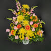 Tall fan-shaped arrangement of yellow and orange blooms with pink accents in a white container