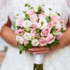 Bride holding a bouquet of pink and white roses
