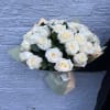 Bouquet of white roses wrapped in pastel paper