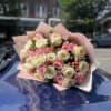 Bouquet of pink and white roses wrapped in pale pink paper