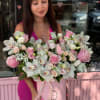 Woman holding a pink box of pink and white flowers