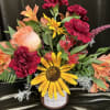 Mixed bouquet with a sunflower, carnations, and alstroemeria in a candle jar