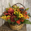 Autumn flower basket with orange roses and yellow mums in a woven basket