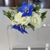 White roses with blue orchids in a clear acrylic holder