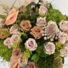 Bouquet of blush and tan roses with pink anthuriums and green filler