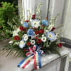 Red and blue floral spray with ribbon bow