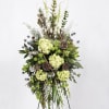 Tall floral standing spray with green hydrangeas and lotus pods