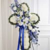Standing floral cross with white and blue flowers and a blue ribbon