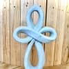 Blue decorative knot sculpture against a wooden background