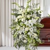 White funeral spray with lilies and roses on a stand