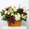 Holiday flower basket with white blooms, red lilies, and a plaid ribbon