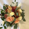 Bouquet of peach and cream roses with burgundy accents