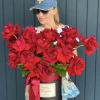 Woman holding a large box of red roses with a ribbon