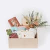 Gift box with dried flowers, baby items, and a cactus plush toy