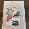 Get well soon card with illustrated dog in cone, sleeping cat, and houseplants on a peach background