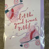 Greeting card with pink roller skates and the words let the good times roll in red script