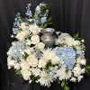White and blue floral arrangement around a silver urn