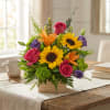 Mixed bouquet with sunflowers, roses, lilies, and purple blooms in a wooden box