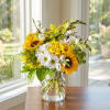 Sunflowers and white daisies in a clear glass vase