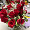 Bouquet of red roses with white filler flowers in a glass vase