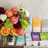 Mixed bouquet beside assorted chocolates and caramels in a wooden gift box