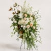 Tall white and blush floral standing arrangement on a metal easel