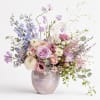 Pastel bouquet of roses, ranunculus, and lisianthus in a ceramic vase