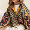 Woman wearing a patterned floral quilted jacket over a white top