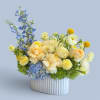 Blue and cream floral arrangement in a white ribbed vase