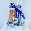 Gift basket with coffee items wrapped in clear cellophane and a blue ribbon