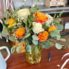 Bouquet of orange and white roses in a glass vase