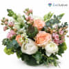 Peach and white roses in a glass vase with pink filler flowers