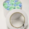 Round box of pastel roses with a gold beaded lid and butterfly accent