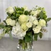 White roses and hydrangeas in a clear glass vase