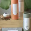 Assorted cylindrical candle tubes on a wooden surface with a small candle dish