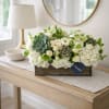 White floral arrangement with succulents in a wooden box