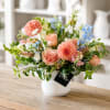 Mixed pastel flower arrangement in a white vase