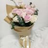 Pink and white rose bouquet wrapped in kraft paper with a ribbon