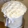 Round bouquet of white roses in a white hatbox with a ribbon