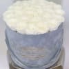 Round box filled with tightly packed white roses in a light blue container