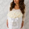 Woman holding a white hatbox of cream roses with a ribbon