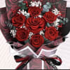 Bouquet of red roses with white filler flowers and dark wrapping