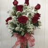 Bouquet of red roses and baby's breath in a glass vase with a red ribbon