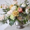 Mixed bouquet of roses and ranunculus in a silver vase
