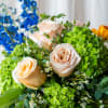 Bouquet of peach roses, green hydrangeas, and blue flowers