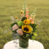 Sunflowers and pale pink roses in a glass vase