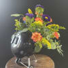 Colorful flower arrangement in a black helmet-shaped container