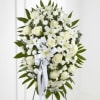 White funeral spray with lilies and roses on a stand