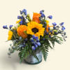 Bouquet of sunflowers, orange roses, and blue flowers in a metal container
