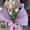 Bouquet of pink and white roses wrapped in lavender paper